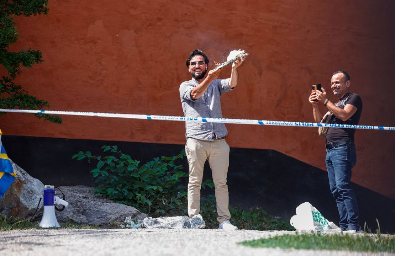 瑞典首都斯德哥尔摩中央清真寺外，一名抗议者撕毁《古兰经》，并用它来擦鞋，然后将培根放入《古兰经》中并点燃